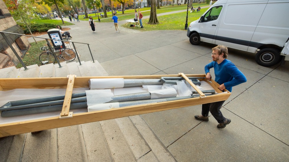 People carry organ pipes on pallet
