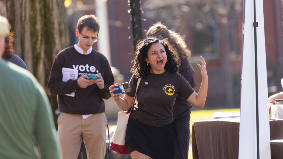 Student in Brown Votes shirt yells with excitement 