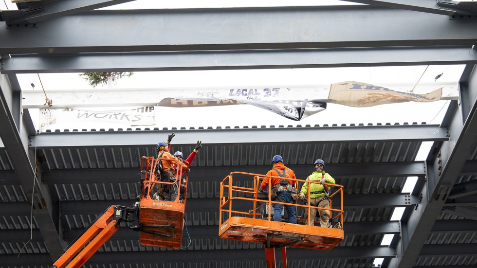 workers cheer after final beam is placed