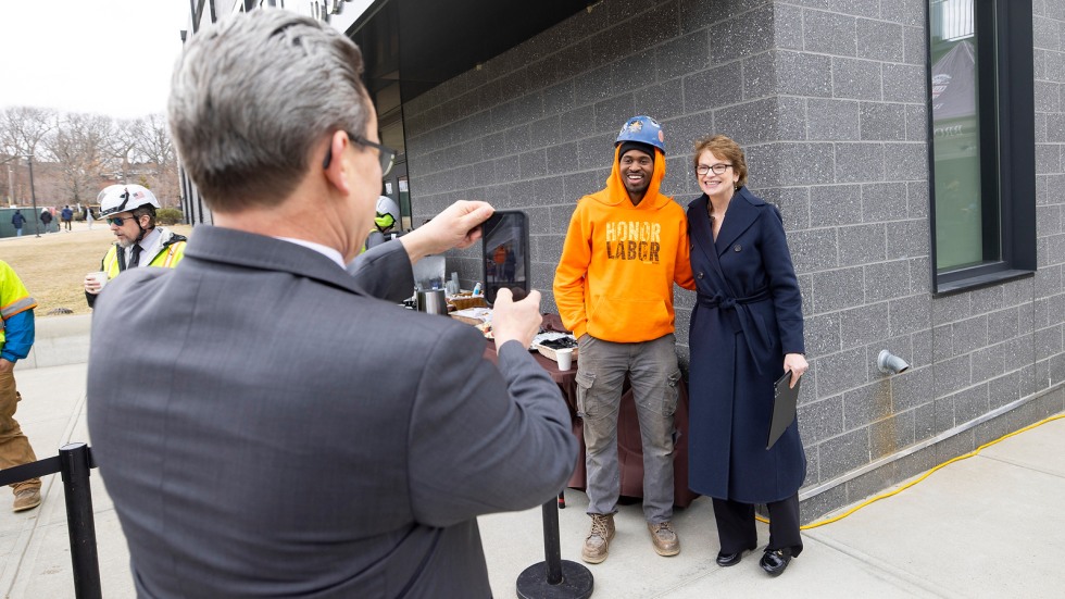 christina paxson stands with building futures worker