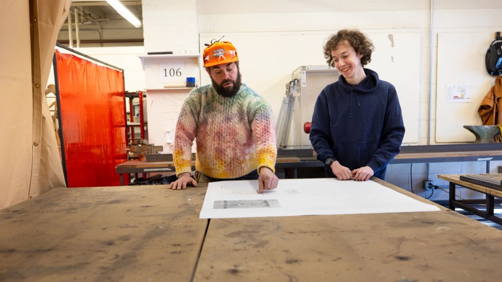 Alexander Haynes works with a student at a large table