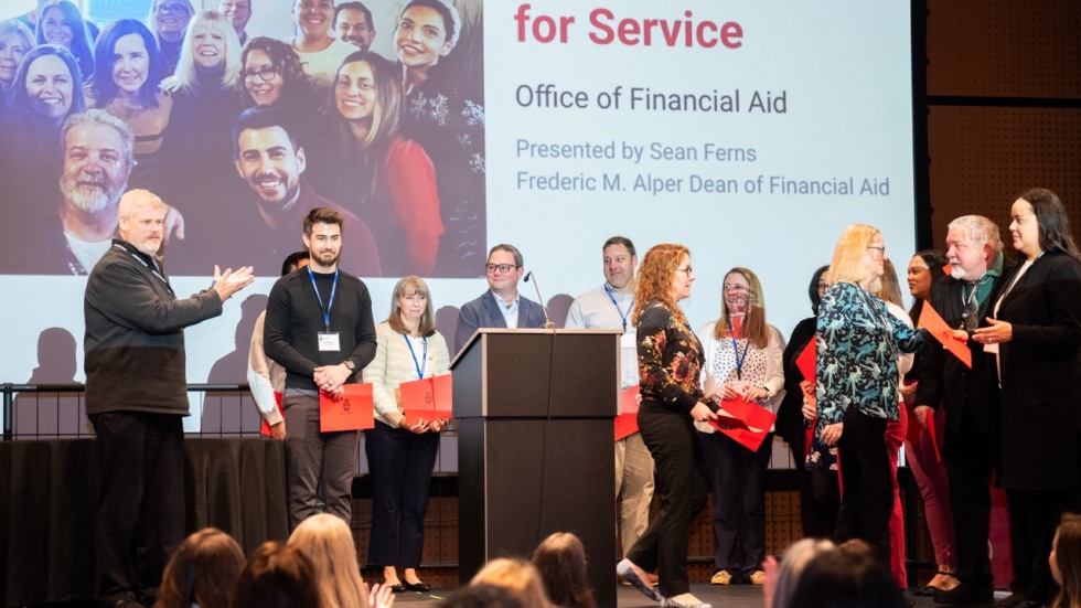 Staff in the financial aid office gather on stage
