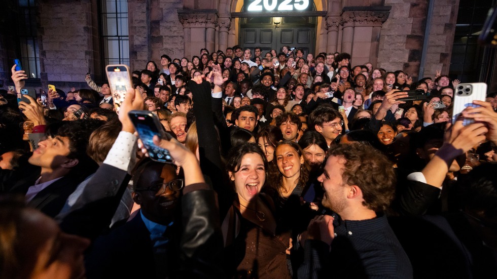 Graduating seniors gather on the steps of Sayles Hall at the end of the night