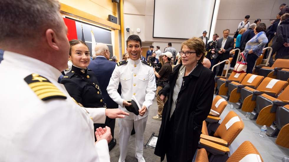 Brown President Christina Paxson stands talking with event attendees