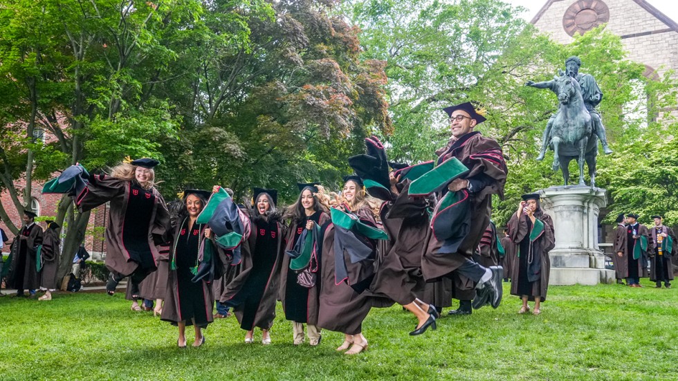 graduates jump in the air