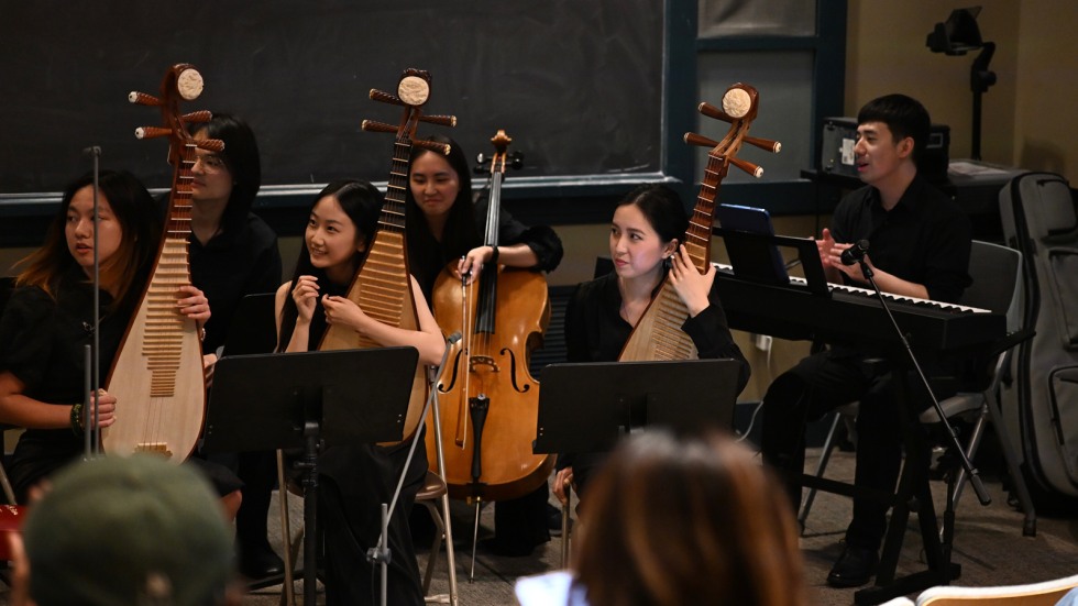 String section of the Bamboo Rhyme ensemble looks up from their instruments