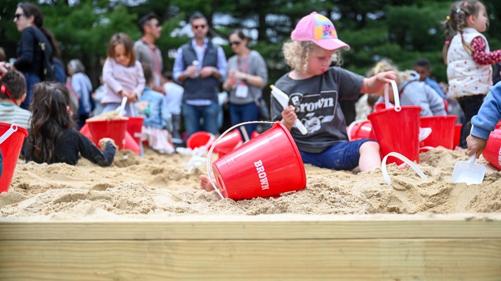 A child playing in a large sandbox