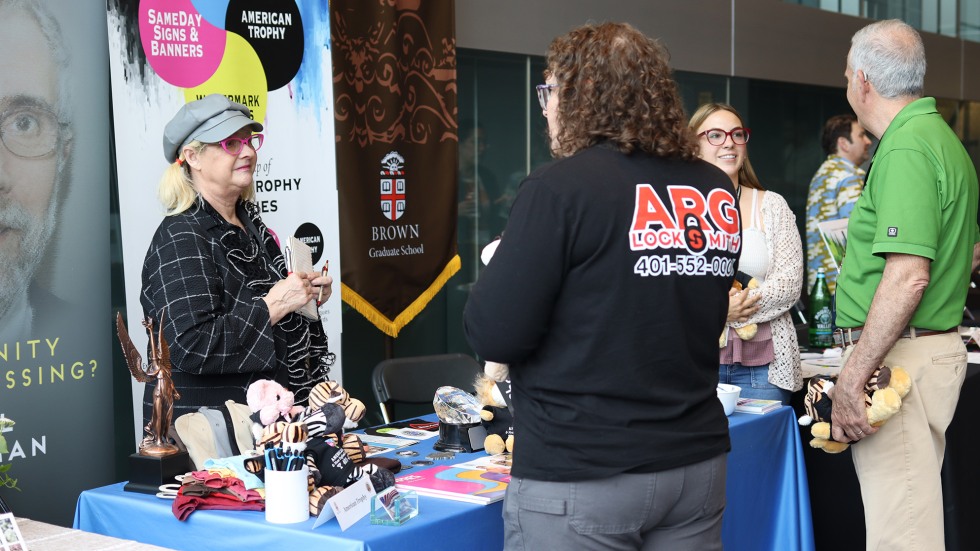 summit participants stop and talk among tables at the showcase. 