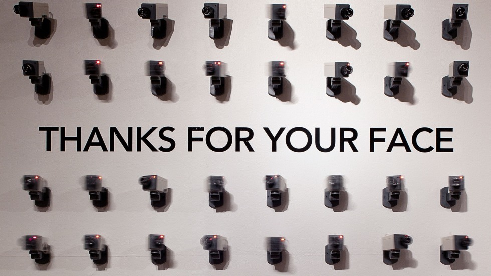 Surveillance wall of cameras with text reading THANKS FOR YOUR FACE