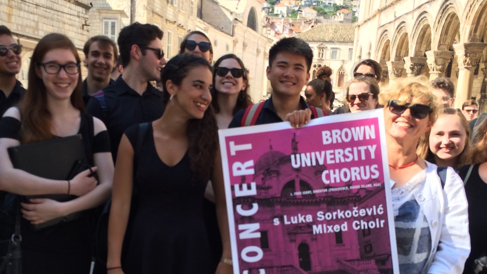Chorus members holding a poster