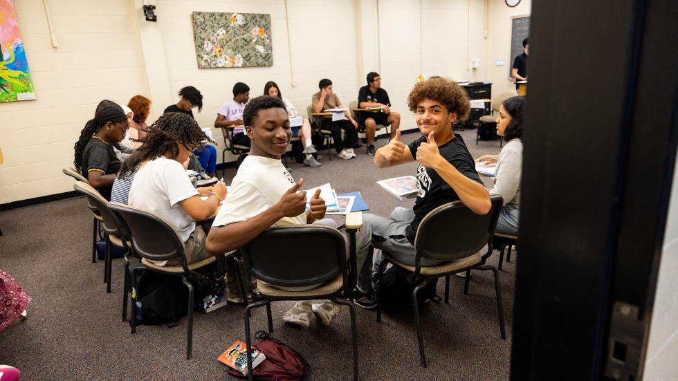 students gesture a thumbs up in class