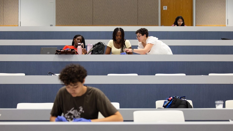 A Brown graduate student works with a student in a classroom