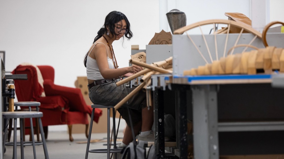 Ran Zhao works at a bench in the sculpture studio