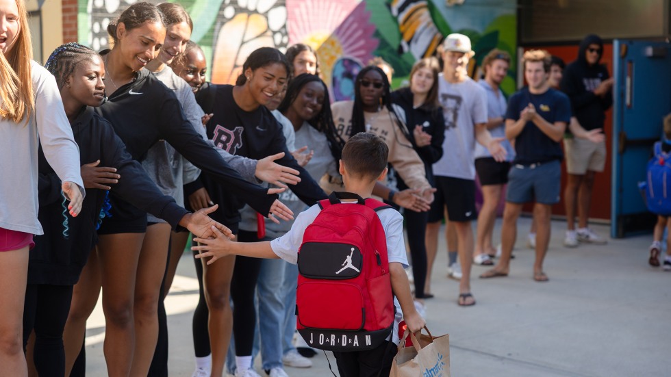 the student-athletes greeted each one with wide smiles, clapping, cheers, encouraging words and outstretched hands ready for high-fives and fist bumps. 