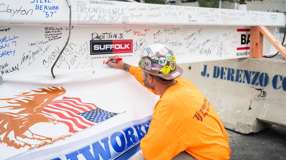 construction worker signing beam at Danoff Labs topping-off