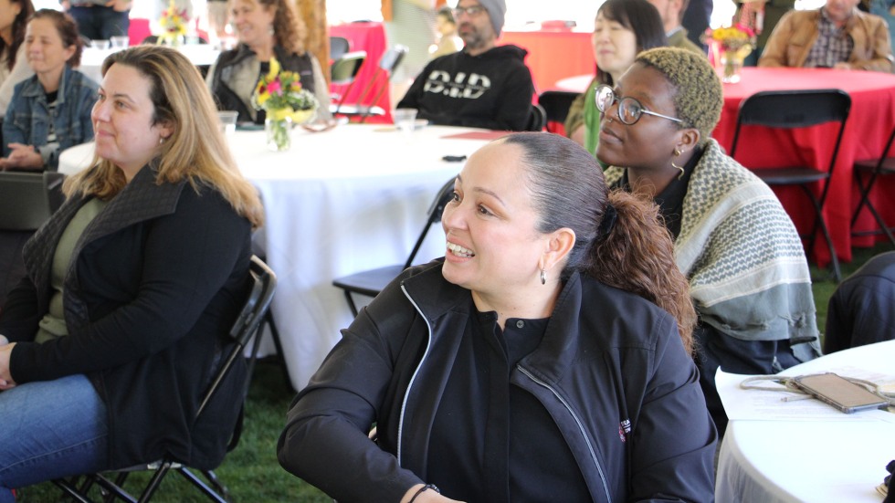 Inoa sits among other Swearer Center staff at a center meeting