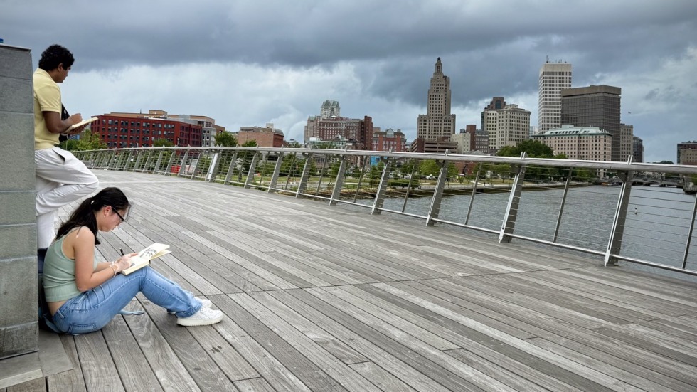 students work on sketches on a bridge
