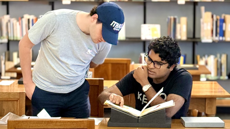 two students examine a book