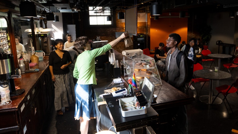 Barista hands order to customer over the counter