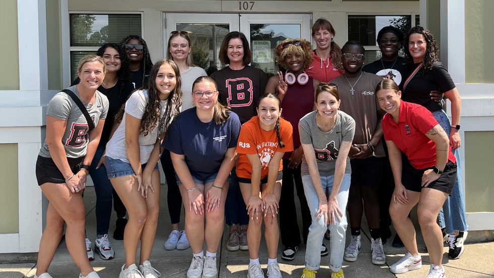 group poses outside of a building