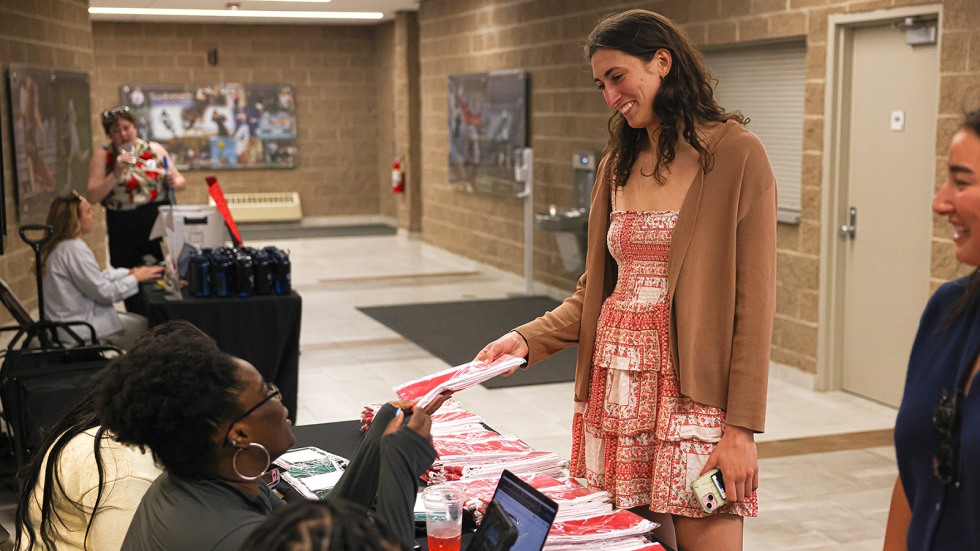Vicky Mealer-Flowers hands a program to a student