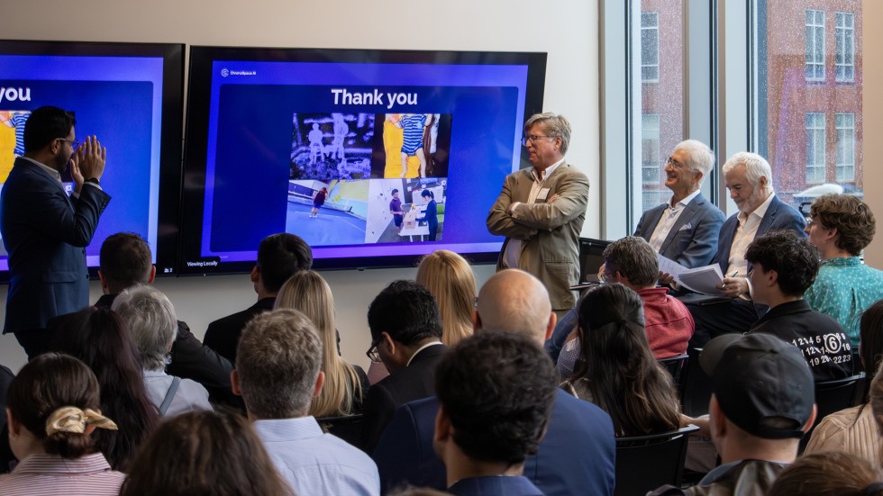 Brown faculty presents his company at the front of a packed room