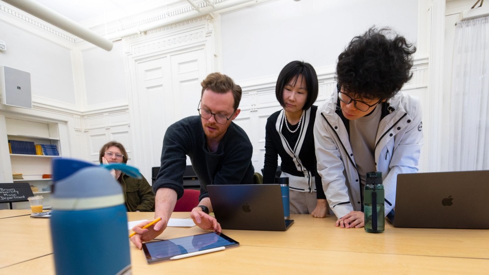 Wang Lu works at a table with students