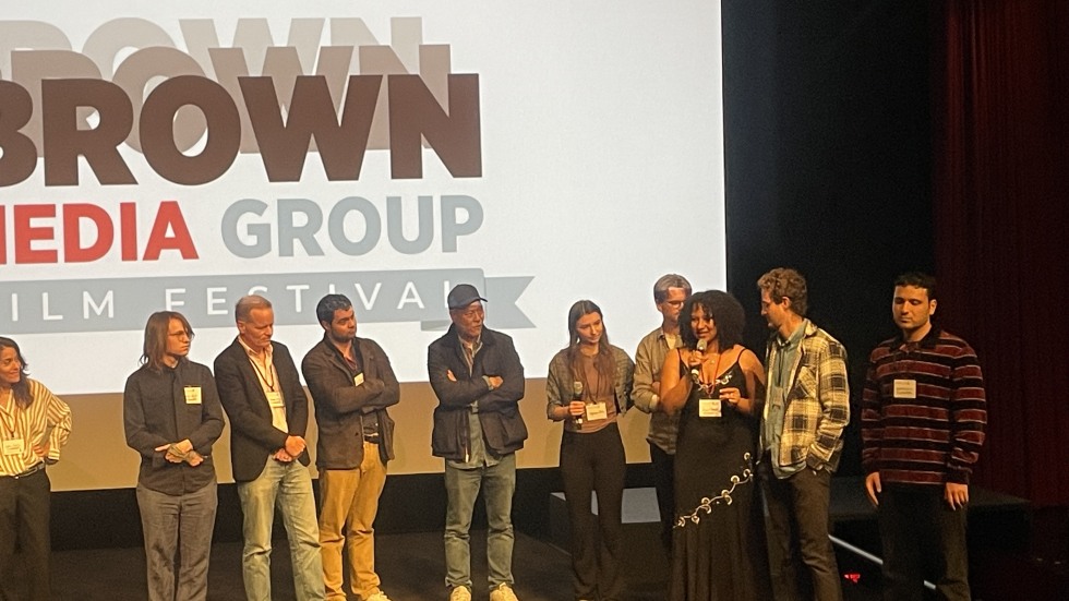 Paige Censale speaking on stage with a group of people
