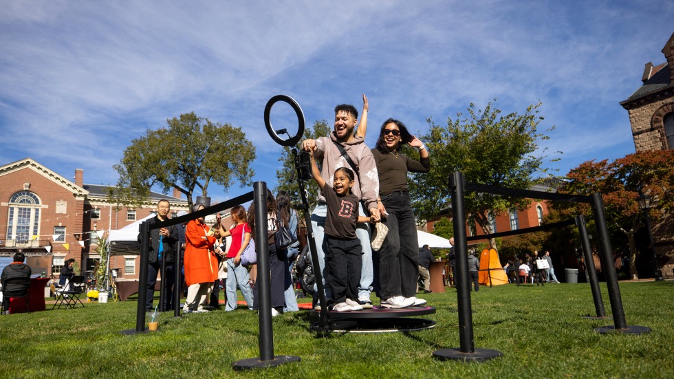 A family joins together on a platform to take a 360 photo. 