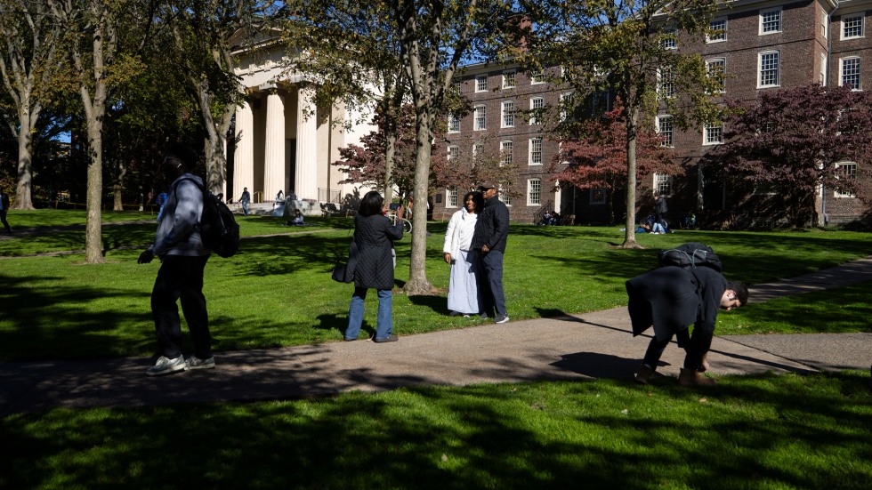 Brown student Caroline Knight stops to take a photo with her father in front of University Hall on Brown's campus. 