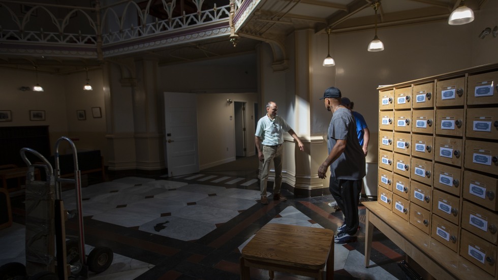 John Colarusso stands with colleagues, pointing to projects that need attention in a building structure 