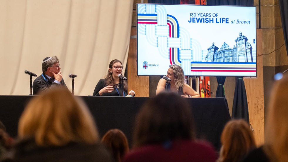 three panelists on stage in Alumnae Hall