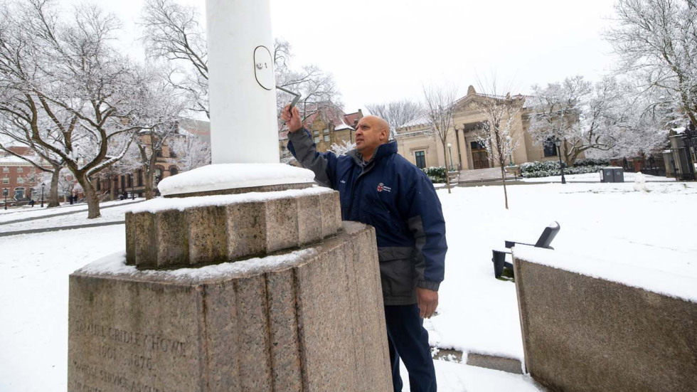 a worker lowers a flag to half mast