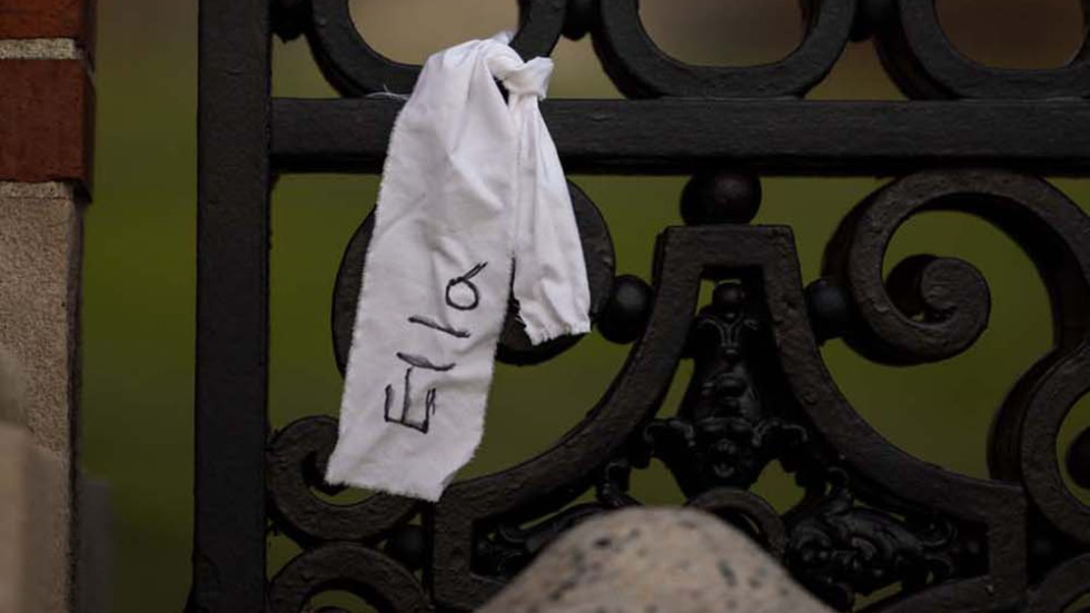 ribbons with writing on them hang from iron gates