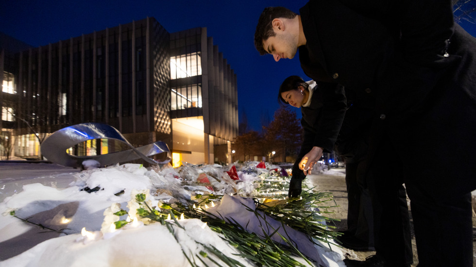 people place flowers at the memorial at the Engineering Research Center