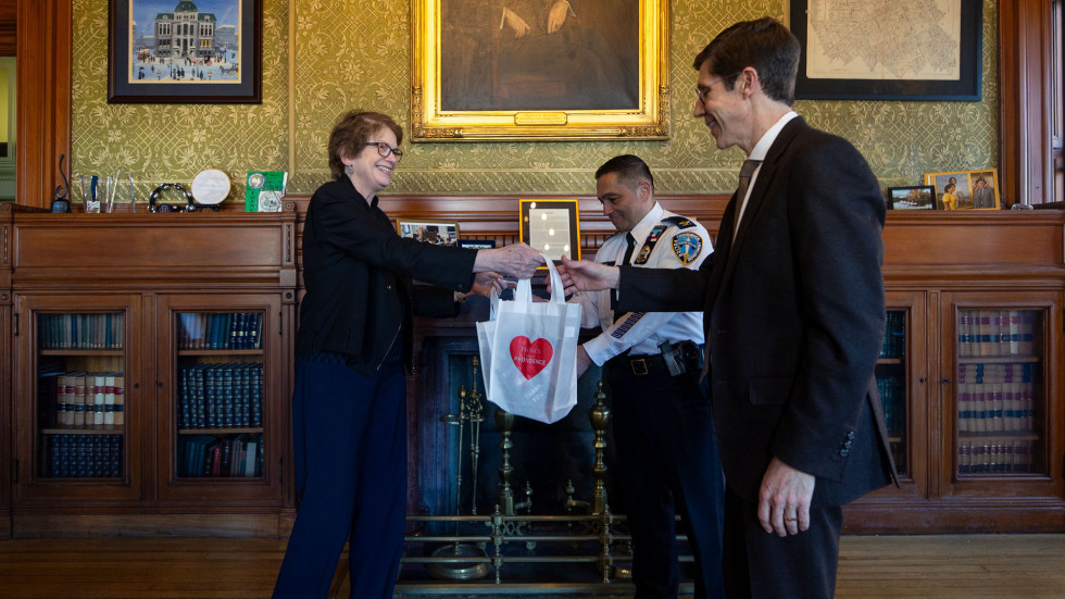 Brown President Christina Paxson hands Mayor Smiley a gift bag and thank-you cards.