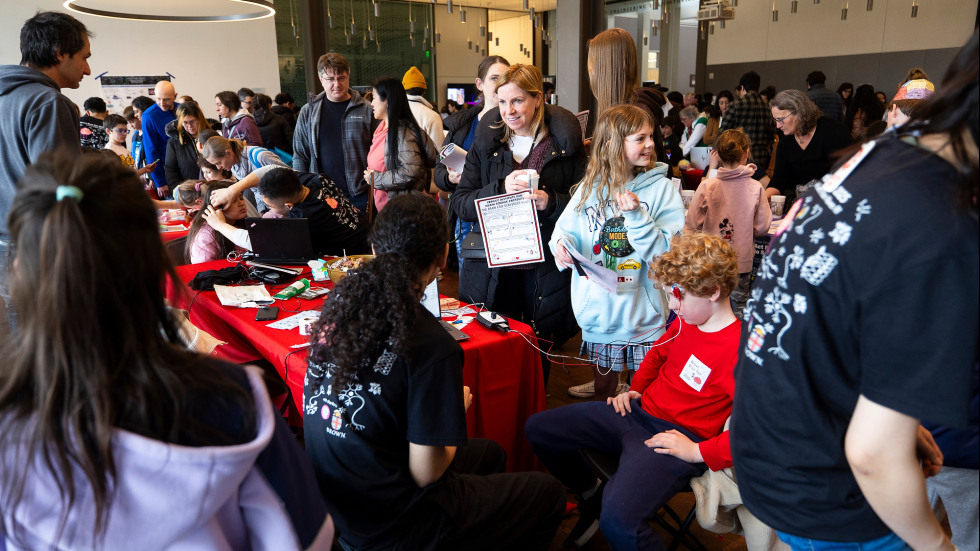 Parents and kids stop along a row of tables with games, puzzles and hands-on demonstrations showing the inner workings of the brain.