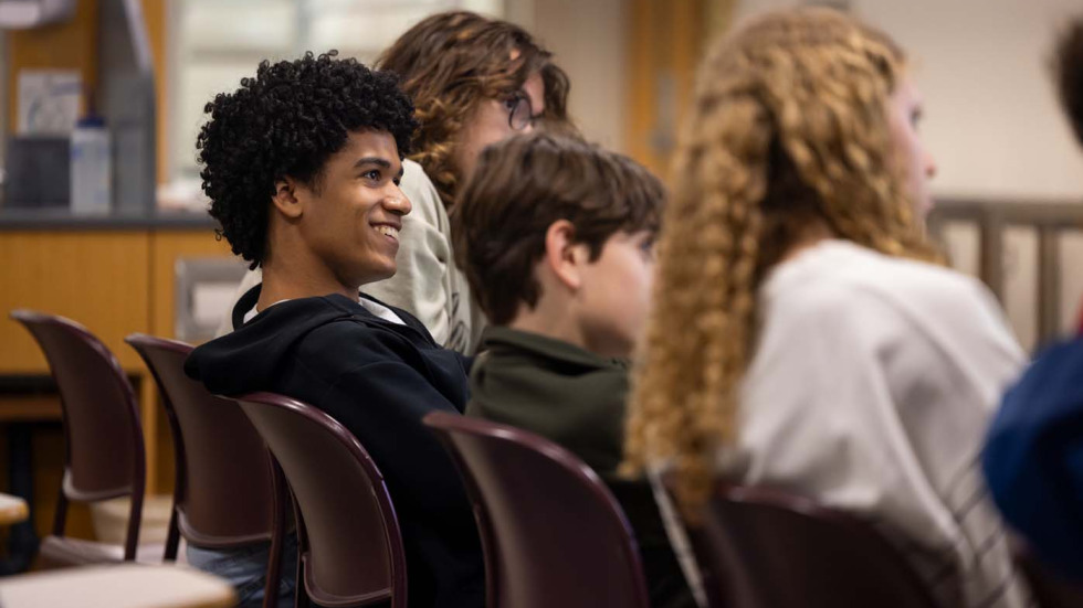students sitting in a classroom, smiling