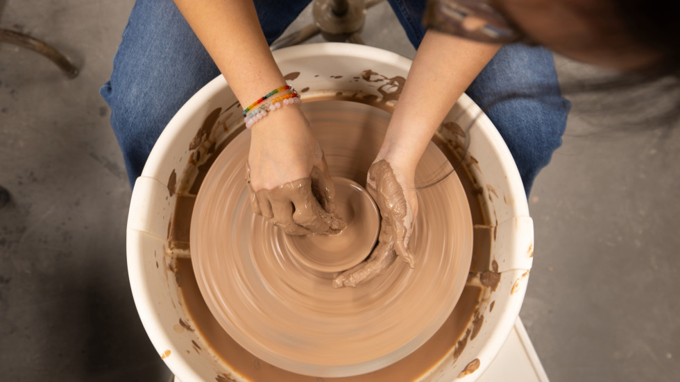 Detail image of hands shaping clay