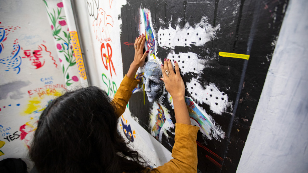 Rishika Kartik uses her hands to feel a tactile artwork she installed in the List Art Building stairwell