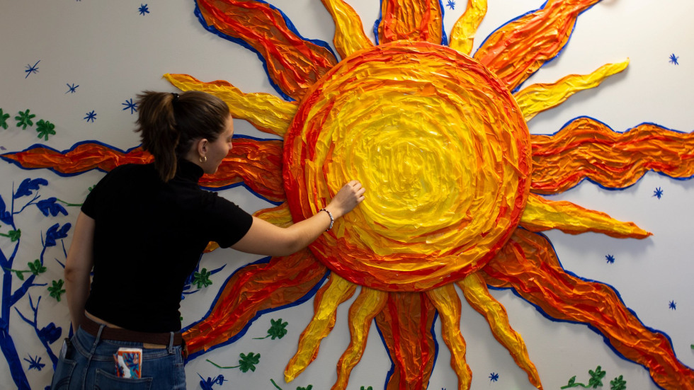 a student touches the sun made of tape