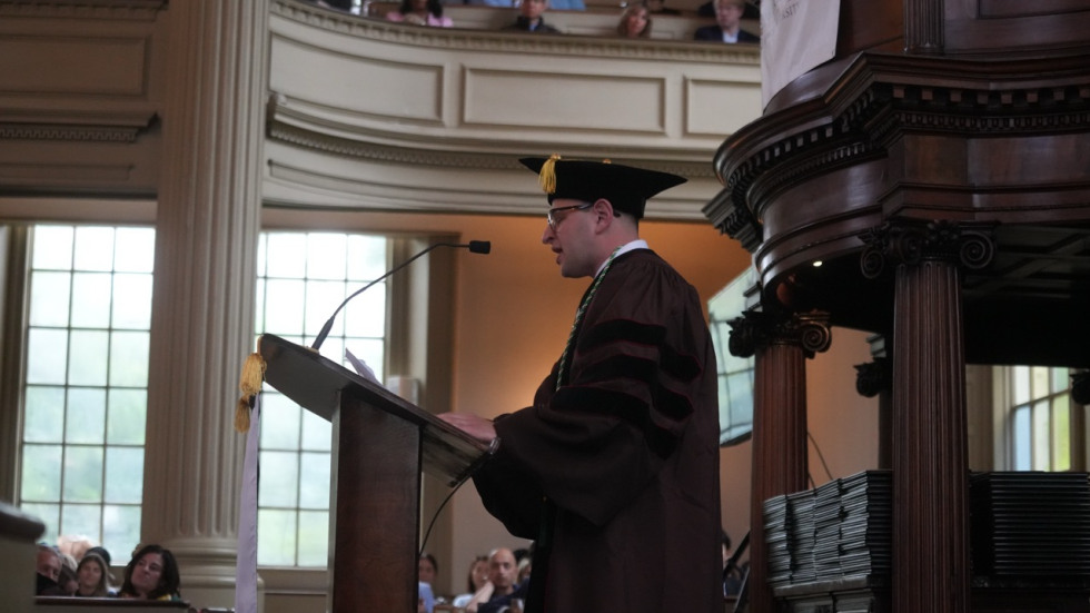 Meylakh Barshay stands at a podium and delivers the student address