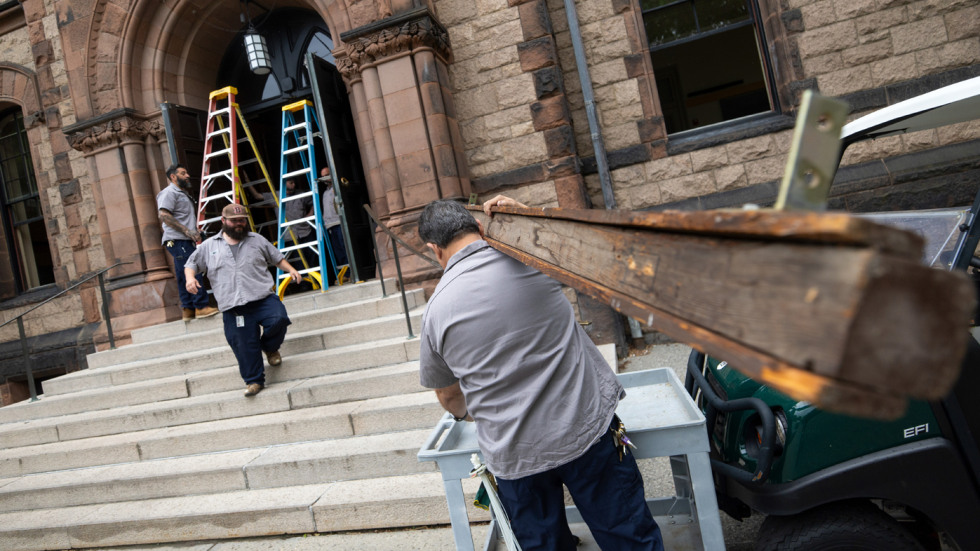 Facilities workers install a 2026 sign