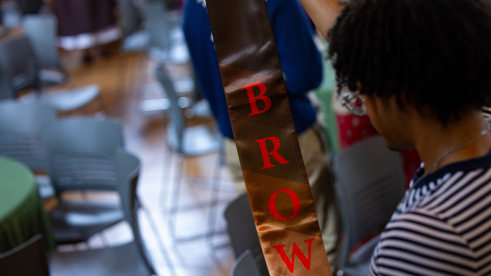 Student holds up a Brown stole