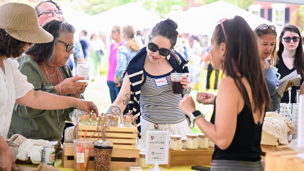 people browse a table at an outdoor market
