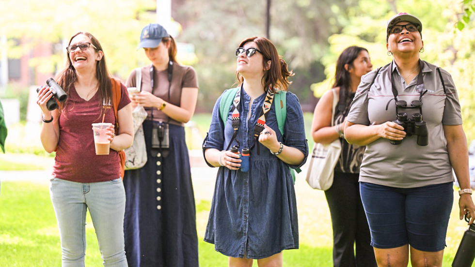 people walking with binoculars around their necks