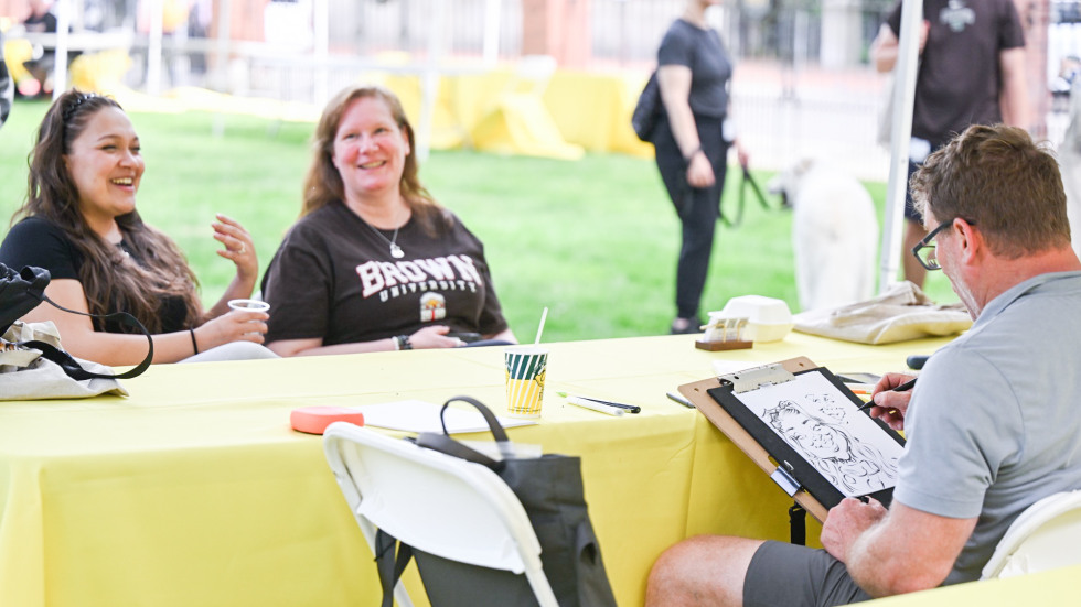 an artist draws a caricature of two people