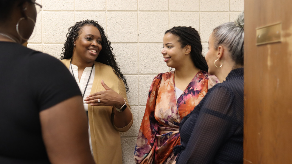 Brown staff talk with PPSD staff in a hallway after dropping prom for all donations