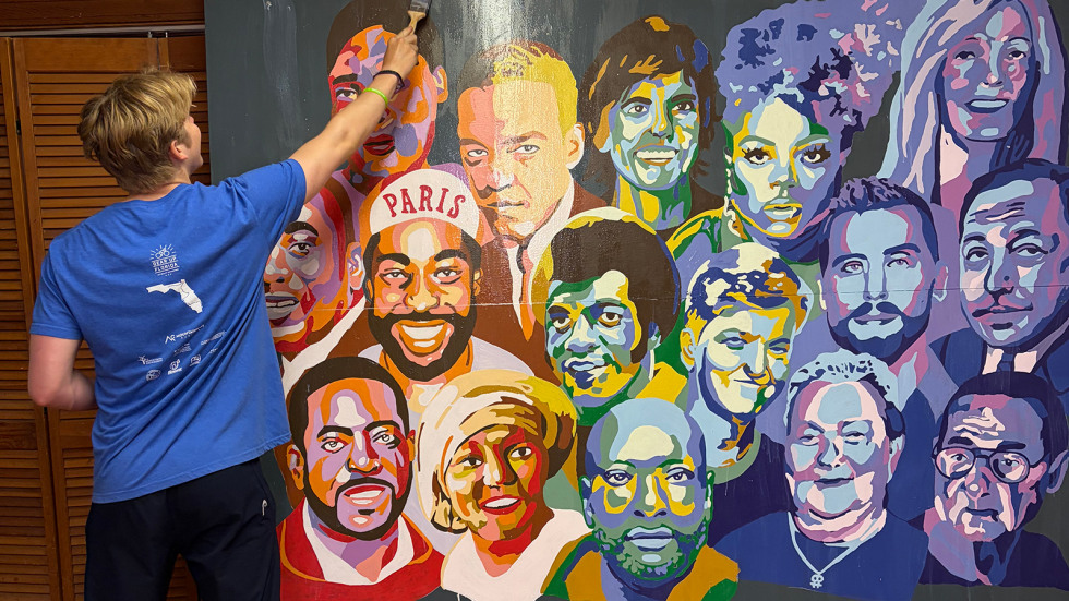 Lachlan Kirby paints a mural in the Spectrum Center