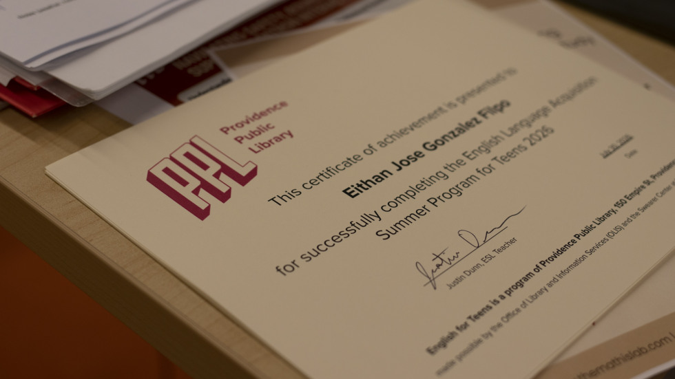 A certificate showing a student's name that completed the english for teens class sits on a table. 